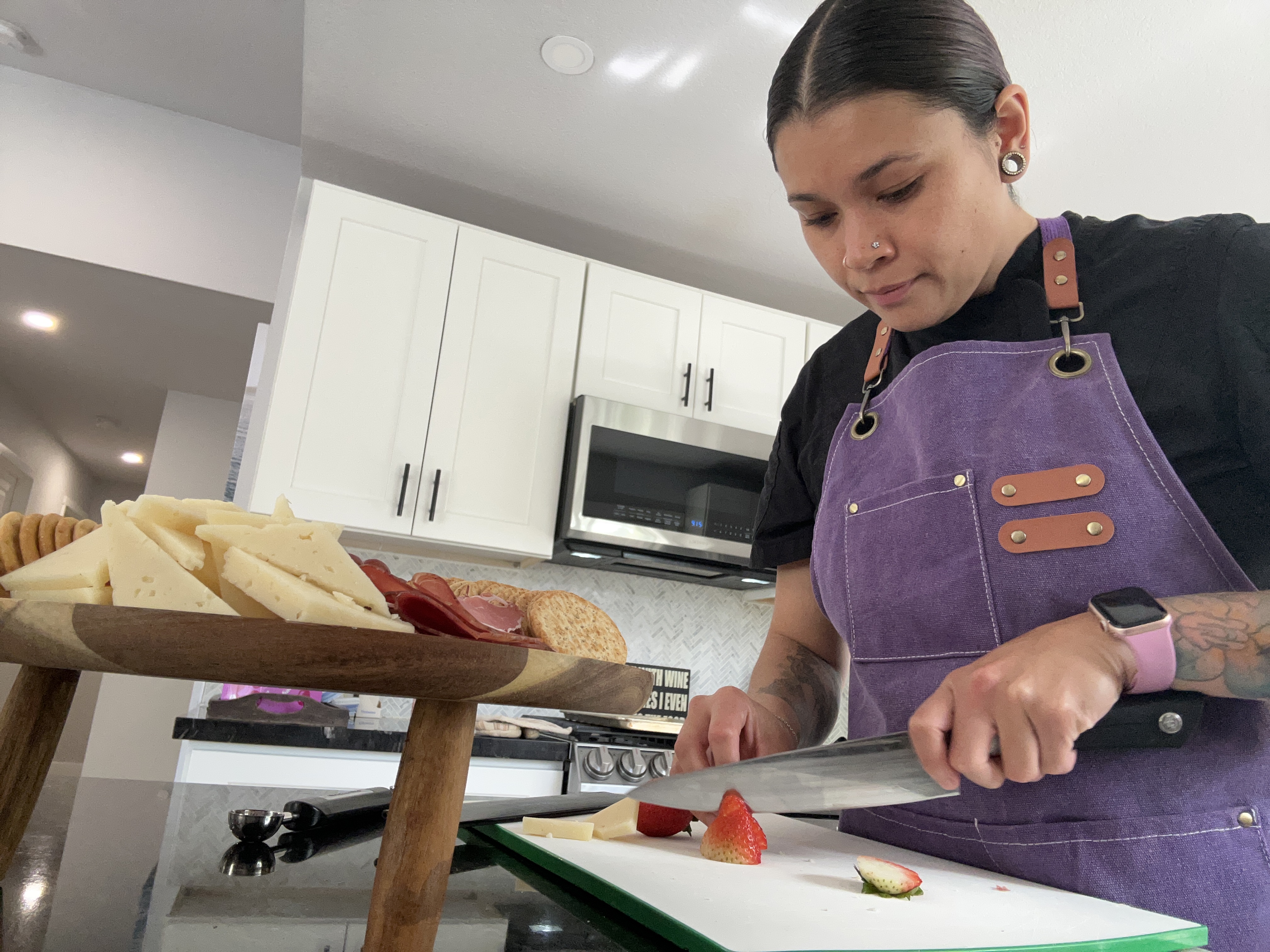 Chef Erika preparing fruit and cheese for a private dining spread